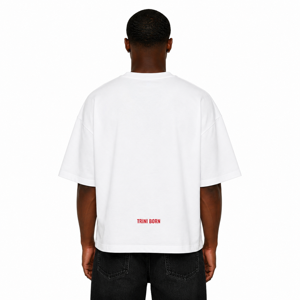 Back view of Black male model wearing the Trini Born oversized white T-shirt featuring subtle red Trini Born logo near the lower back on a clean white studio background.