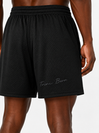 Close-up of Trini Born black mesh shorts back showing breathable mesh and Trini Born script detail.