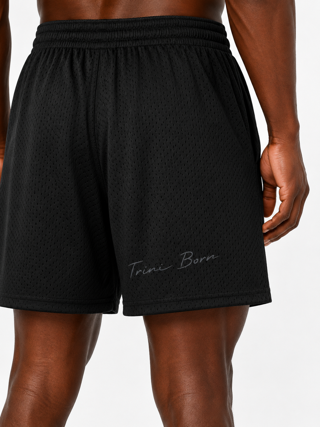 Close-up of Trini Born black mesh shorts back showing breathable mesh and Trini Born script detail.