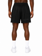 Close-up of Trini Born black mesh shorts showing breathable mesh, white drawstring and Trinidad and Tobago graphic.